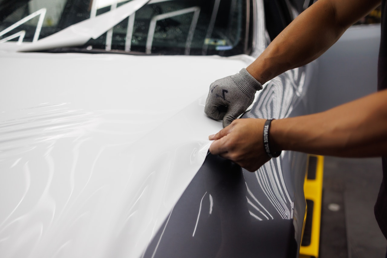 what surfaces can you vinyl wrap - man vinyl wrapping an object