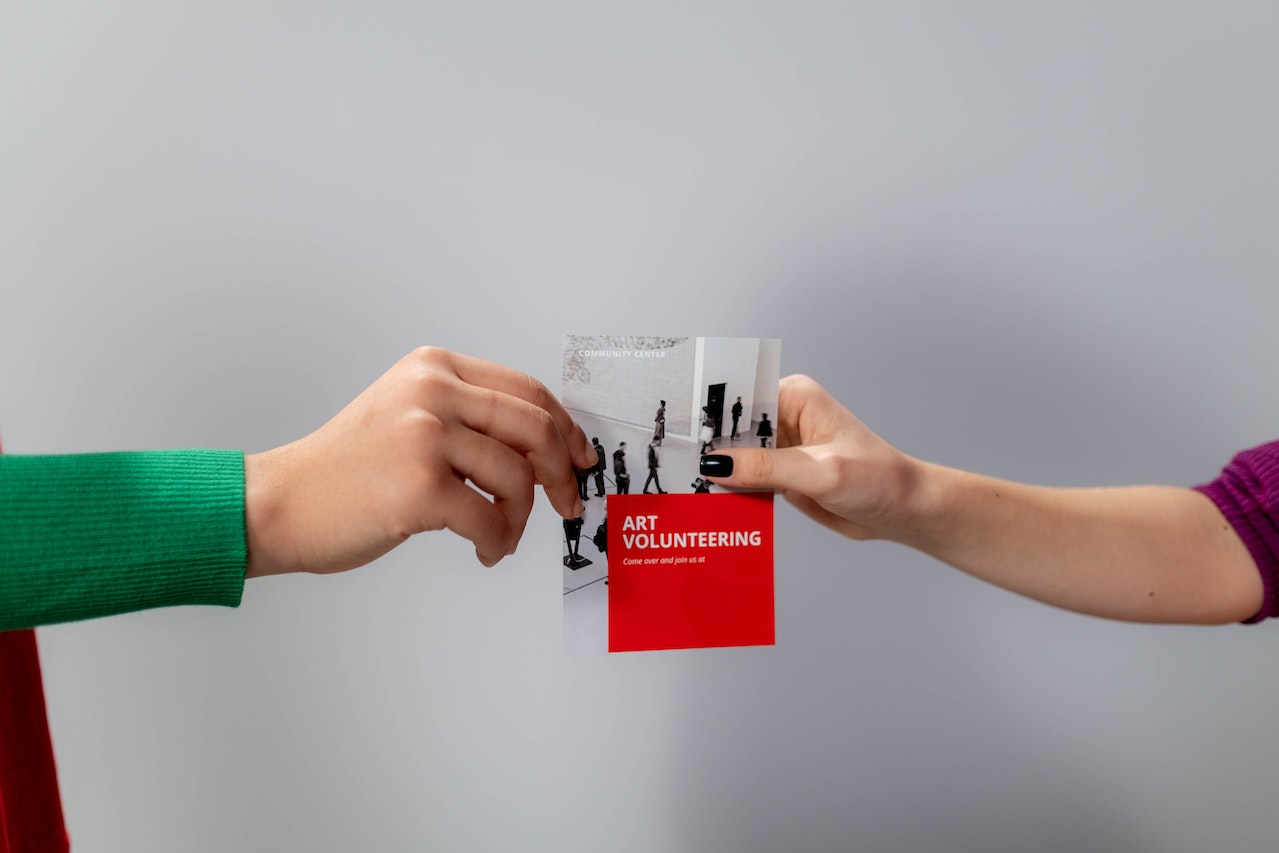 hands exchanging a flyer over gray background