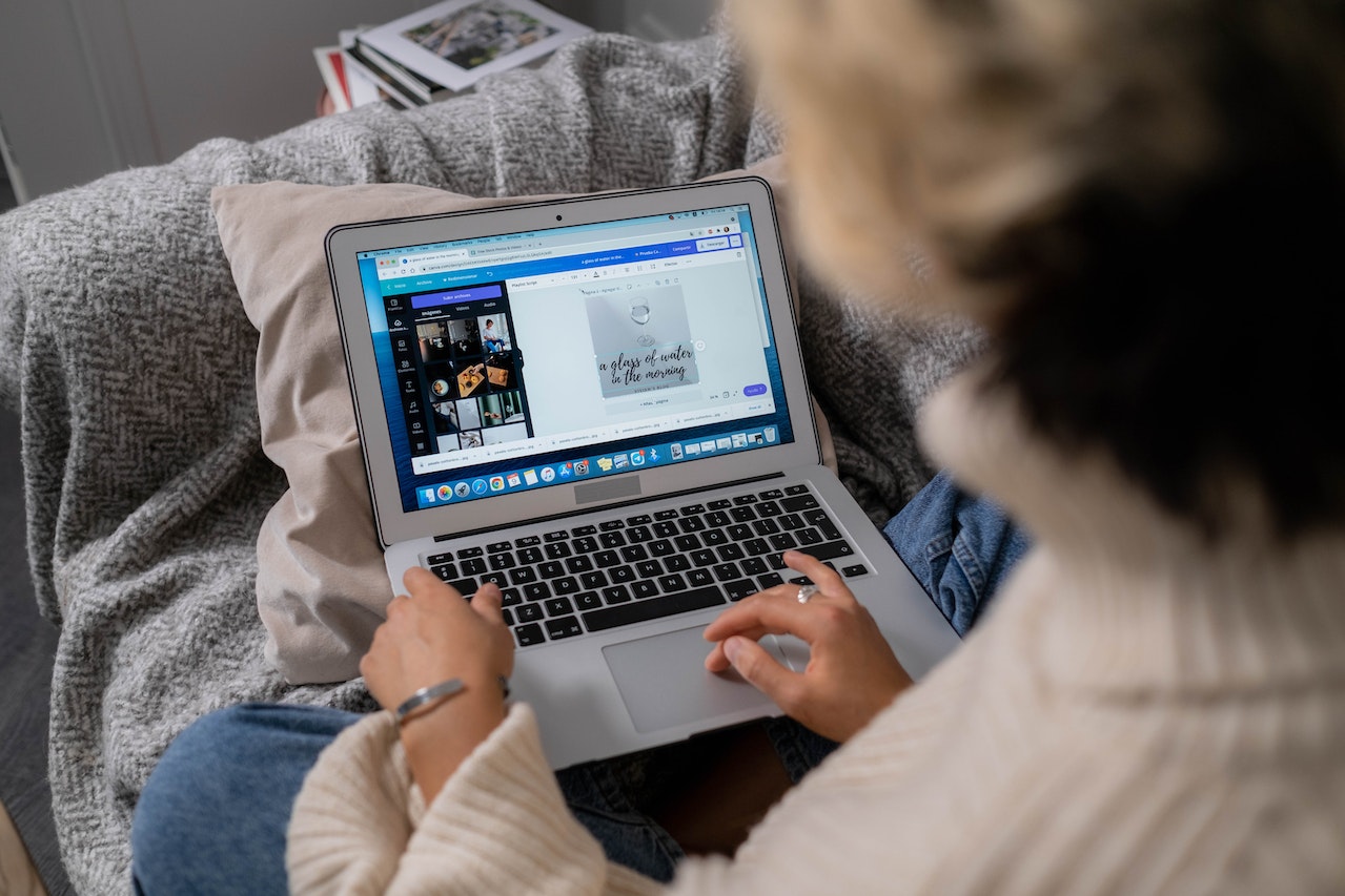 woman using canva website on laptop